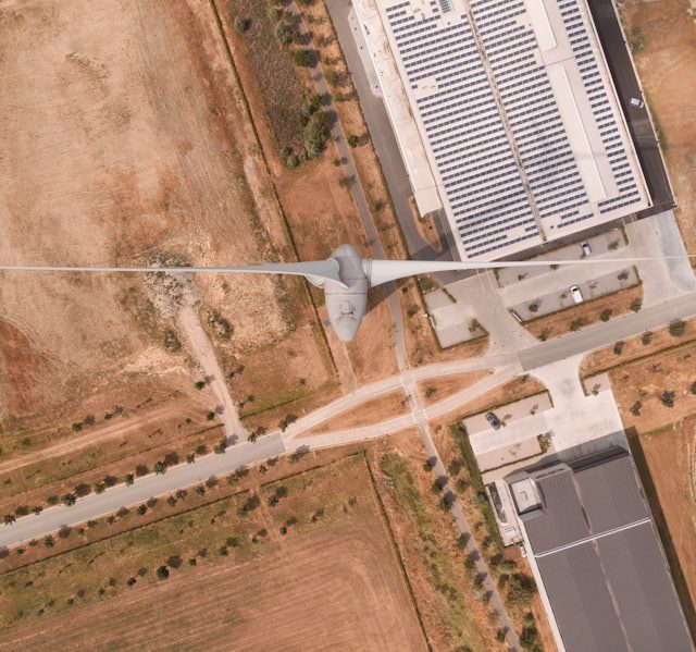Vista aérea de área industrial com turbina eólica e painéis solares