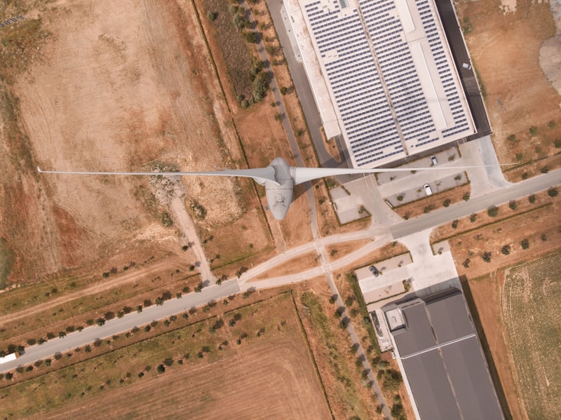 Vista aérea de área industrial com turbina eólica e painéis solares