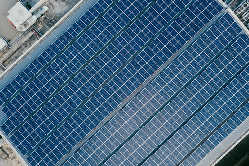 Painéis solares em telhado industrial vistos de cima